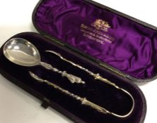 A Victorian cased caddy spoon and tongs with Apostle decoration. London 1880. By Charles Edwards.