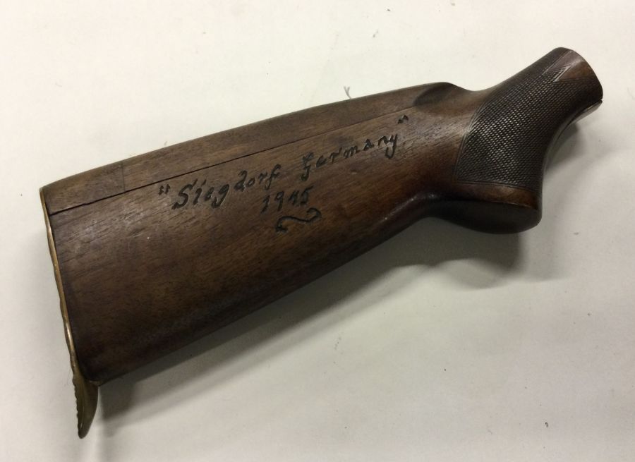 An old wooden rifle butt with Nazi carving. Est. £