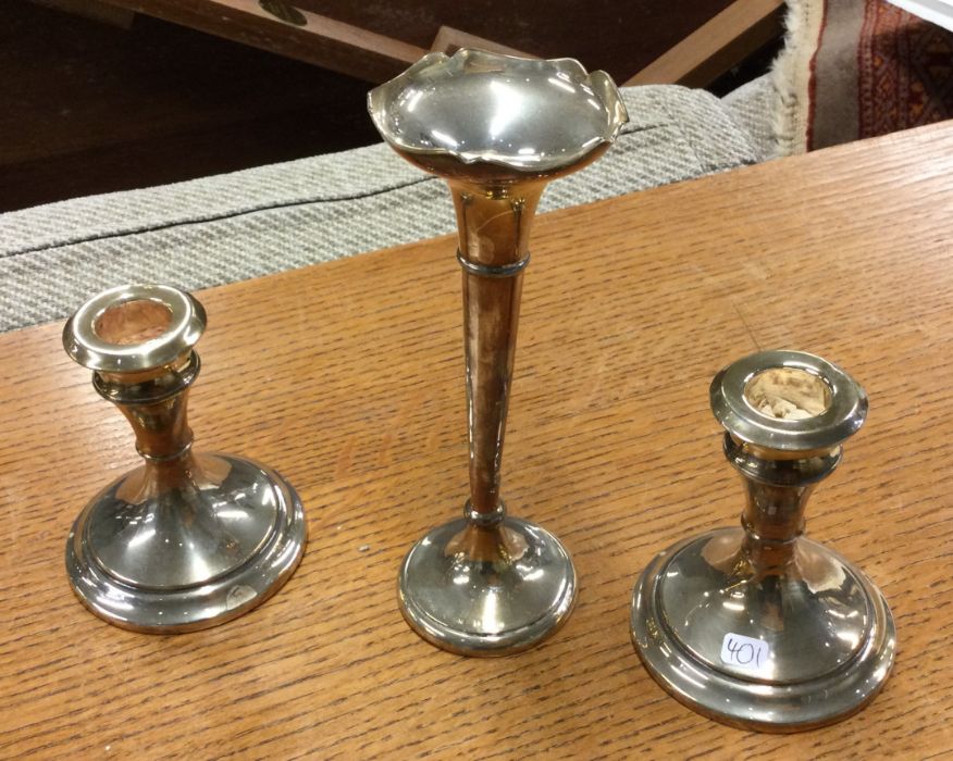 A pair of silver candlesticks together with a vase