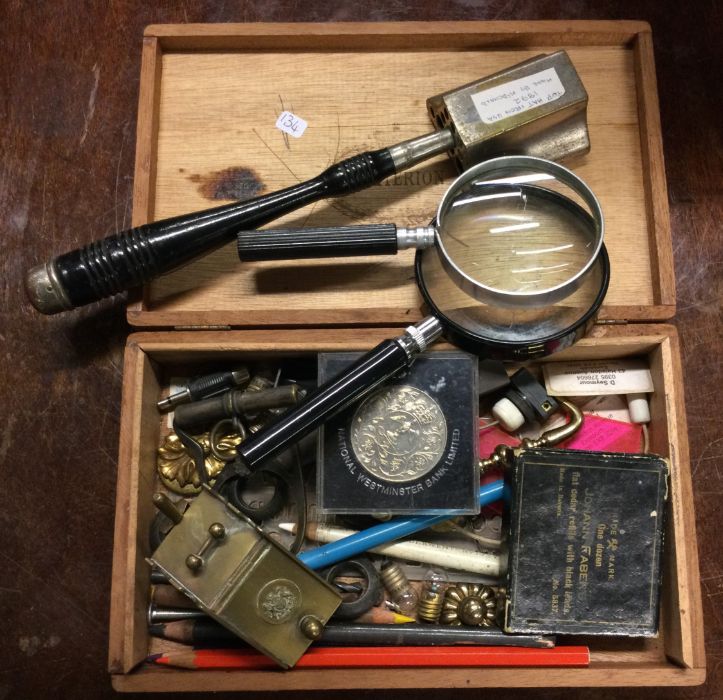 A box containing magnifying glasses, coins etc. Es