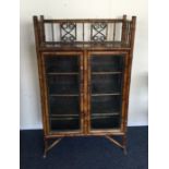A bamboo two door glazed cabinet. Est. £200 - £300