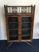 A bamboo two door glazed cabinet. Est. £200 - £300