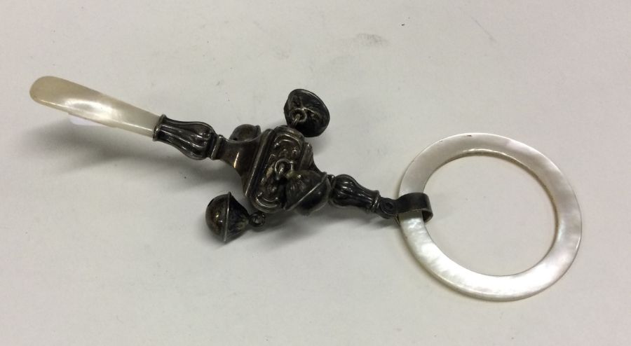 A silver and MOP rattle. Approx. 28 grams. Est. £50 - £80.