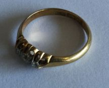 A small diamond three stone ring in gold mount. Ap