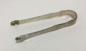 A fine pair of George III silver sugar tongs with bright cut decoration. London circa 1790. Maker’