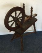 An old spinning wheel. Est. £20 - £30.