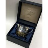 STUART DEVLIN: A rare cased silver porringer of chased floral design to commemorate the