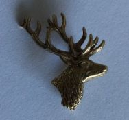 A small gold brooch in the form of a stag. Approx.