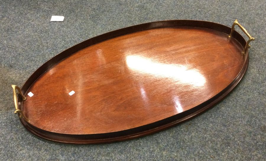 An oval brass mounted and mahogany tray. Est. £20