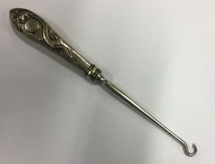A heavy Chinese silver button hook. By Chang. Approx. 66 grams. Est. £50 - £80.