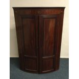 A Victorian mahogany bow front corner cupboard. Es