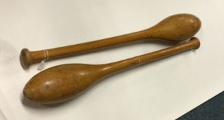 A pair of heavy wooden Indian juggling clubs. Est.