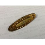 An oval gold boat shaped brooch inset with diamond