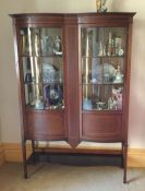 An Edwardian bow front display cabinet. Est. £100