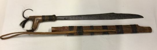 A Continental carved tribal knife in sheath. Est.