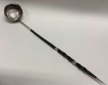 A large 18th/19th Century silver and whalebone toddy ladle with coin to centre. Approx. 48 grams.