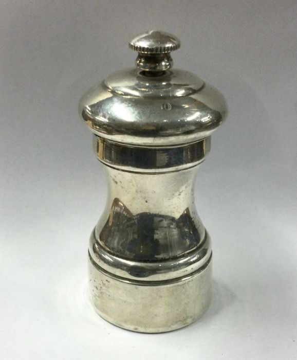 A silver pepper grinder of typical form. Approx. 1