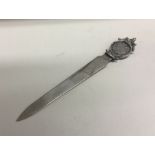 A silver letter opener inset with coin bearing import marks. Approx. 30 grams. Est. £25 - £35.