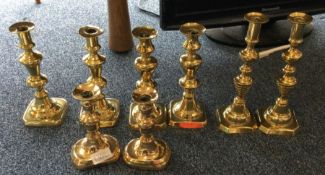 Four pairs of brass candle sticks. Est. £20 - £30.
