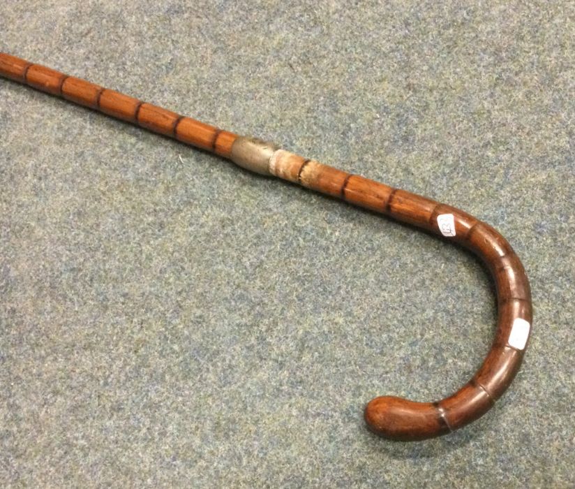 A silver mounted and engine turned walking stick.