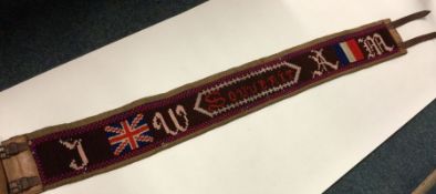 A World War II souvenir embroidered wool belt. Est