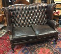 A button back leather settee. Est. £40 - £60.