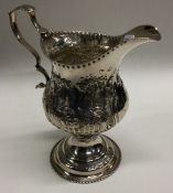 A fine chased Georgian cream jug with decorative scenes. London maker ‘TS’. Approx. 77 grams.