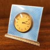 A silver and enamelled mantle clock of stylised fo