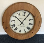A massive pine kitchen clock. Est. £30 - £40.