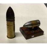 Two old brass shell cases; one mounted upon mahoga