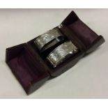 A cased pair of engraved silver napkin rings. Approx. 26 grams. Est. £40 - £60.