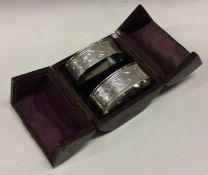 A cased pair of engraved silver napkin rings. Approx. 26 grams. Est. £40 - £60.