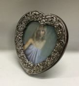 An American silver heart shaped frame. Est. £50 - £80.