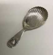 A silver fluted caddy spoon with shell decoration. Birmingham 1900. By SFS. Approx. 13 grams.