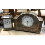 A carriage clock together with one other.