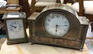 A carriage clock together with one other.