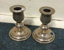 A pair of heavy silver candlesticks with floral de