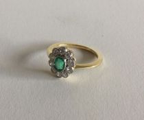 A good emerald and diamond daisy head cluster ring