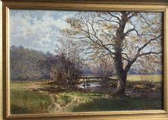 A gilt framed oil on canvas depicting a wooded str