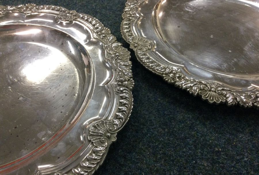 A heavy pair of silver plates with chased borders.