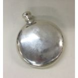 A heavy circular silver hip flask with screw-on co