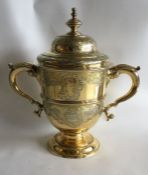 A large chased silver gilt cup and cover on pedest