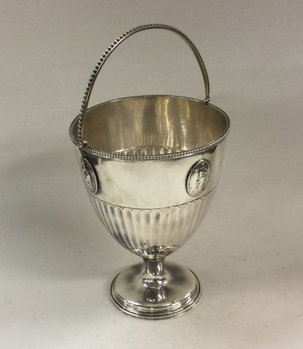 A George III Neo-classical swing handled silver ba