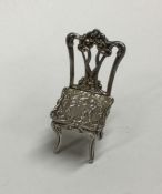 A novelty silver miniature chair with cherub decor