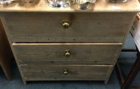 A small pine three drawer chest.