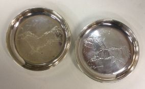 A pair of silver engraved dishes decorated with ho