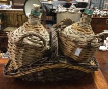 Two wine bottles together with a basket.