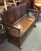 A large hinged top oak settle.