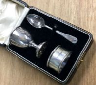 A silver christening set comprising an egg cup and