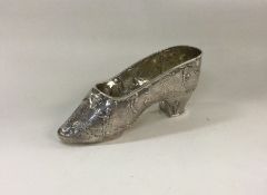 A heavy chased silver miniature model of a shoe, b